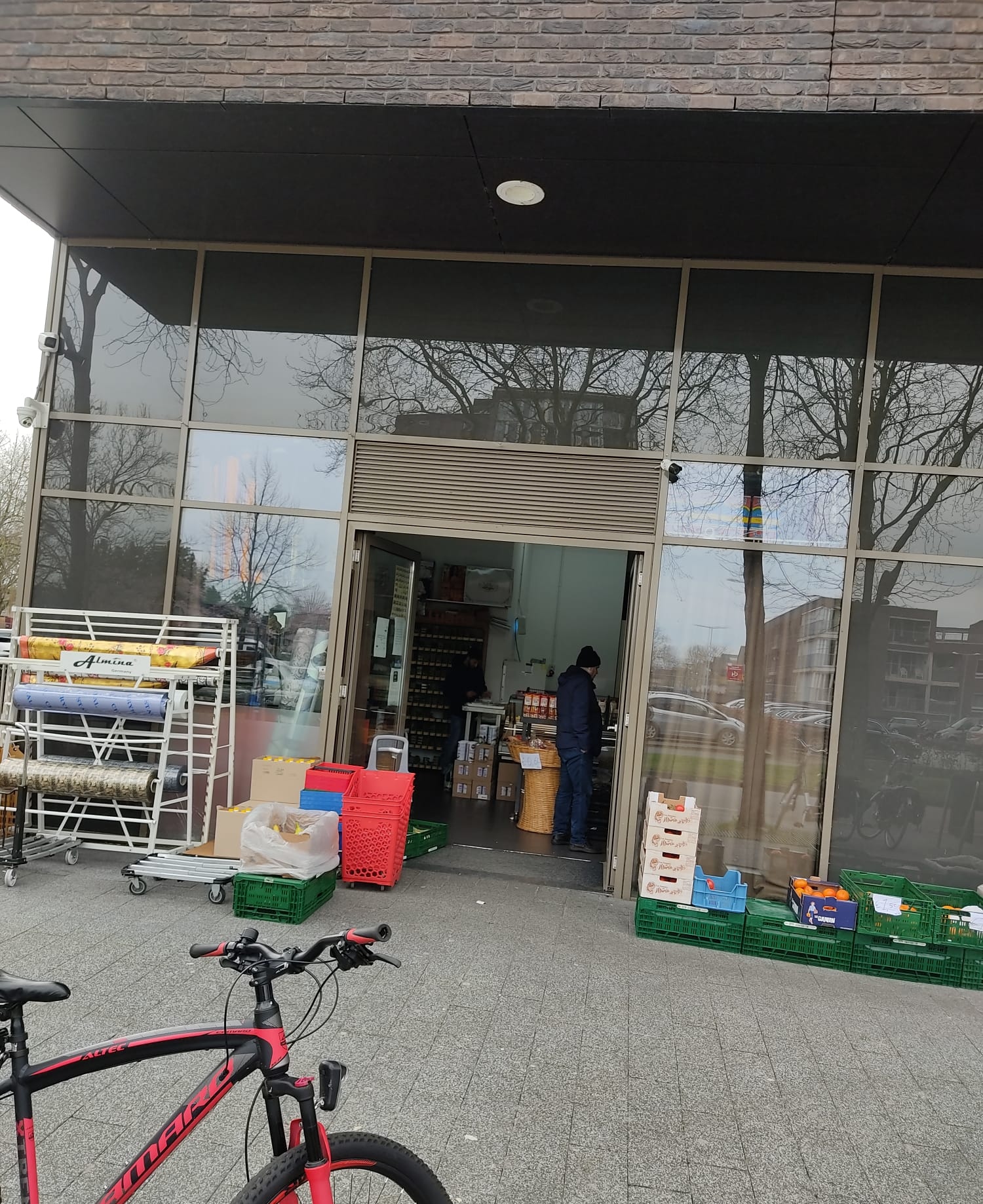 De open deur van de winkel met kratten fruit ernaast